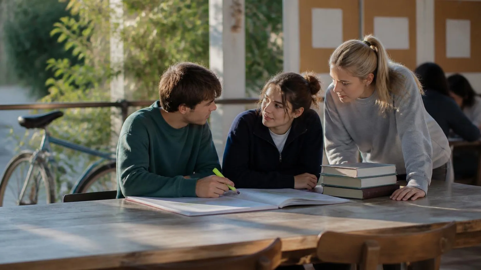 Estudantes conversam sobre o planejamento do semestre em uma mesa compartilhada no campus, com livros e agenda sobre a mesa.